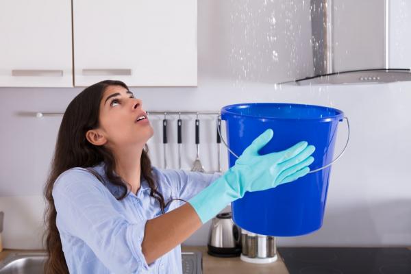 Woman-holding-bucket-for-leaking-roof